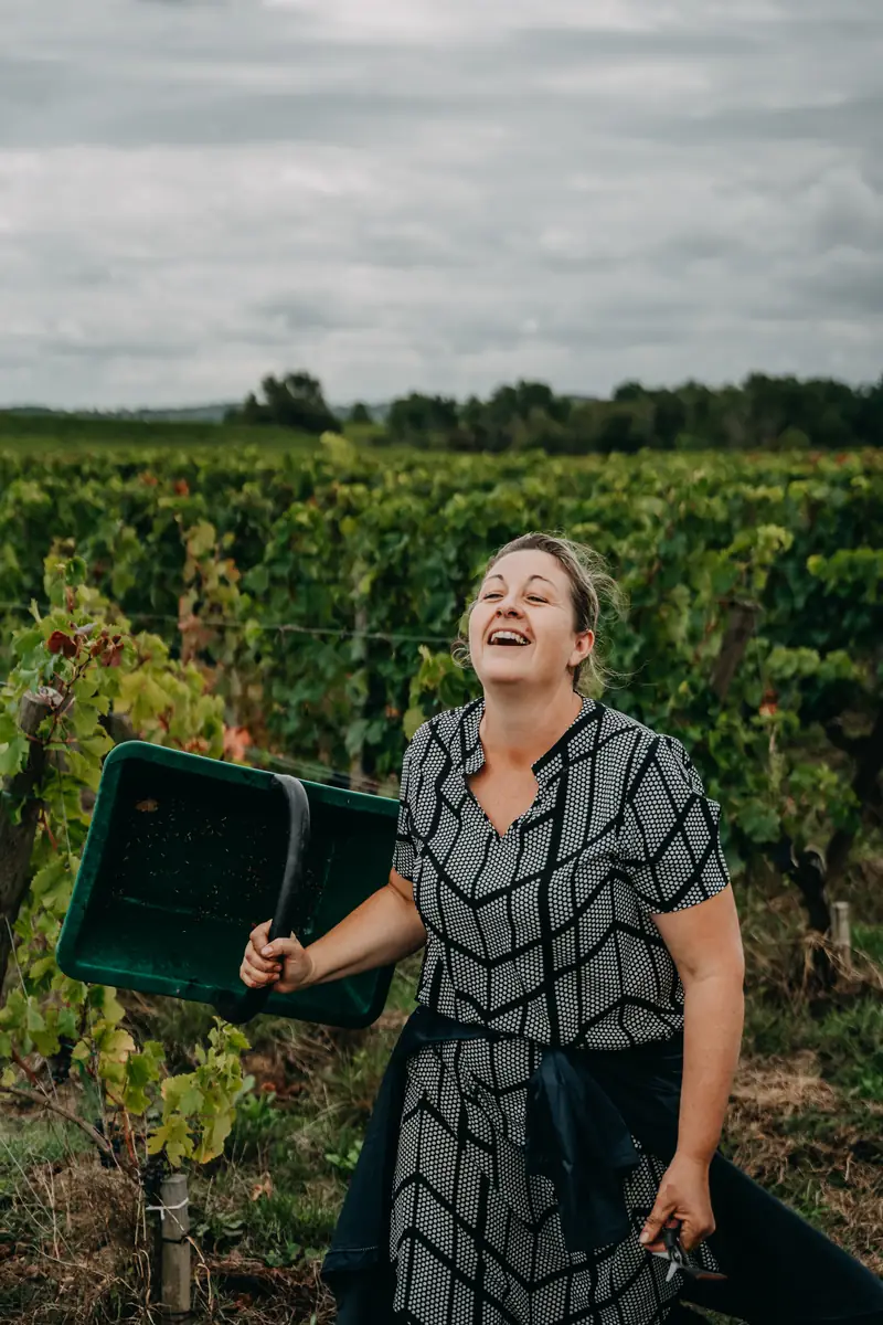 Vendangeuse riant entre les rangs de vigne, vendanges 2025