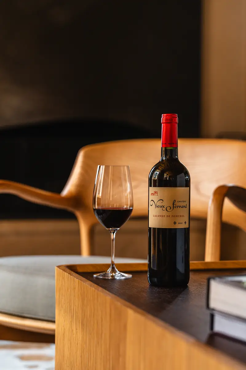 Bouteille de Saint-Émilion et verre de vin rouge dans le salon du château