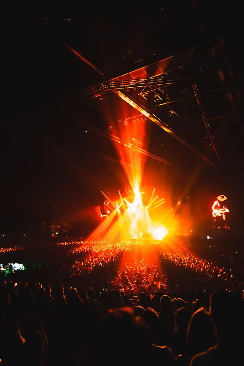 Faisceaux lumineux orangés au-dessus de la scène d'un concert