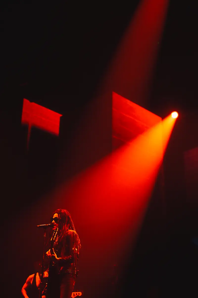 Lenny Kravitz au micro dans les faisceaux rouges