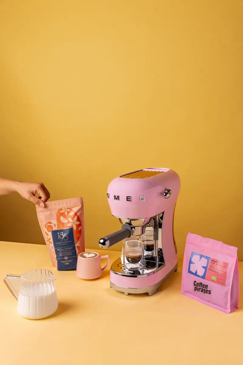 Machine expresso rose et cafés de spécialité sur fond jaune