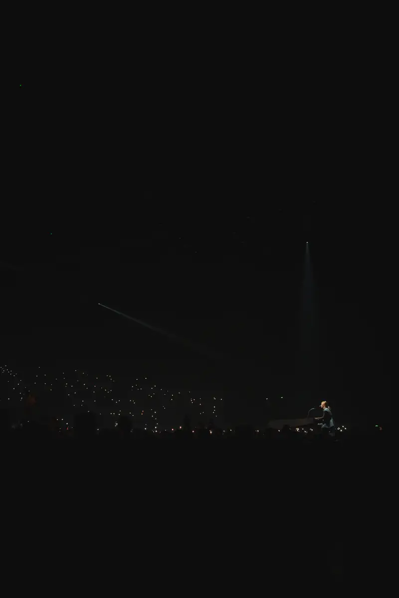Salle plongée dans l'obscurité pendant le concert de Zaho de Sagazan